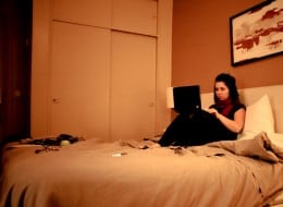 girl in hotel room on laptop