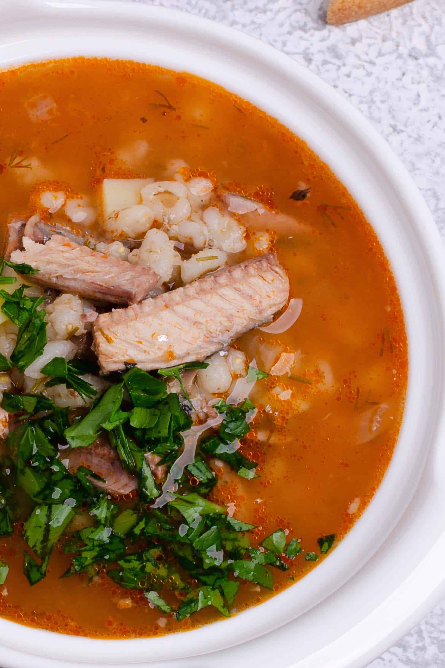 Peruvian fish soup called sudado in a white bowl.