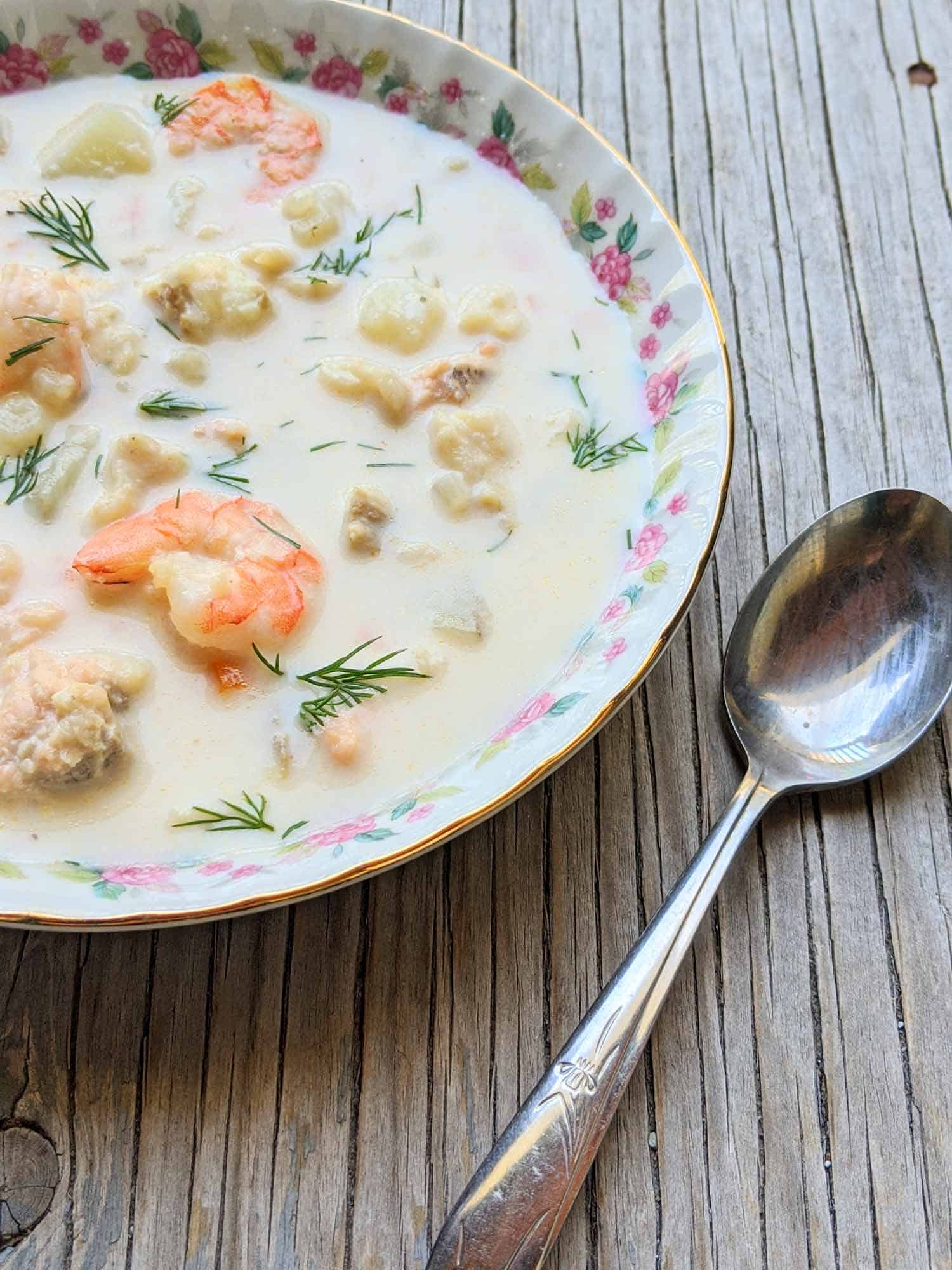 Fish chowder in a vintage bowl on a wooden background.