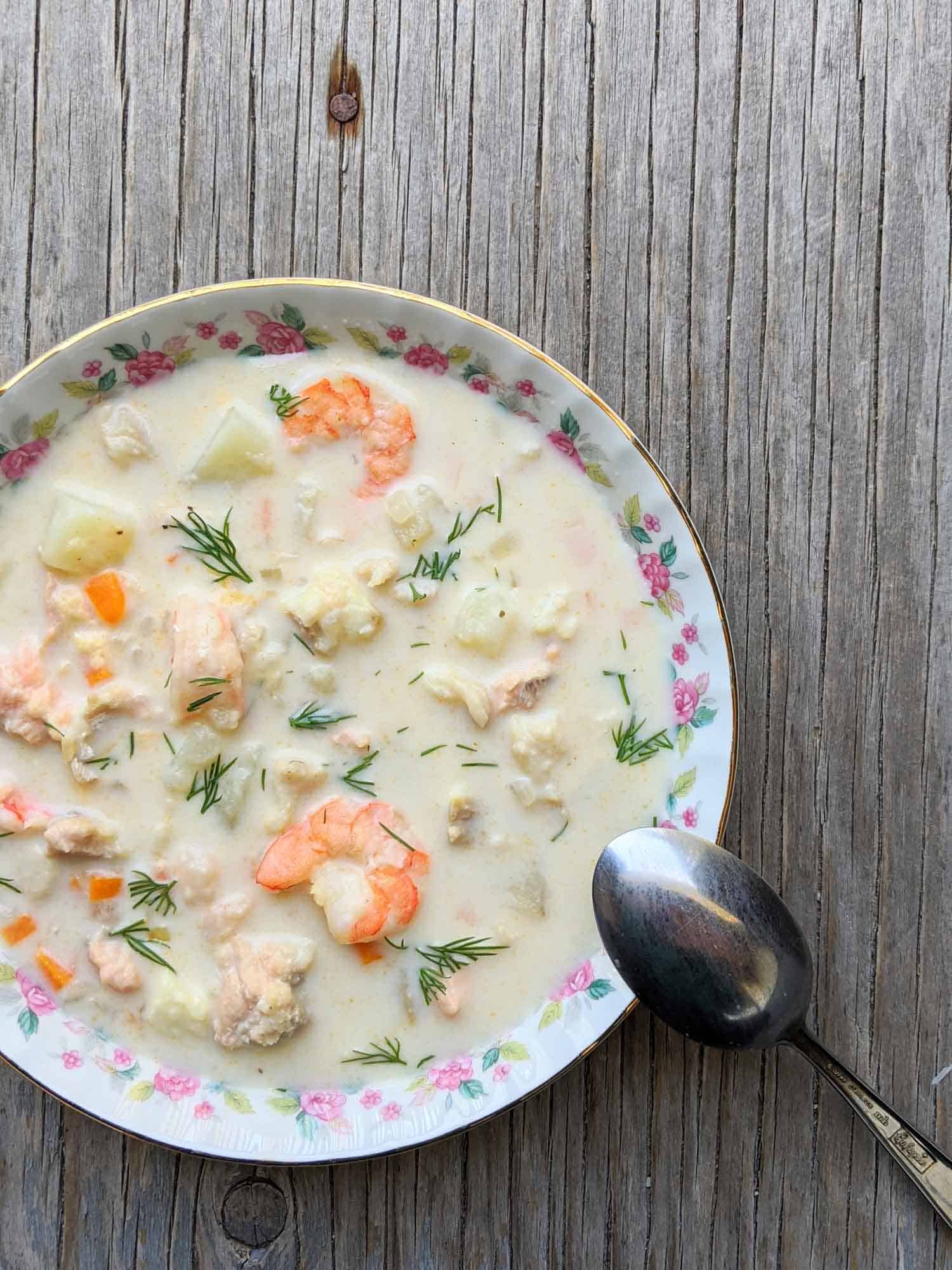 Nova Scotia seafood chowder in a vintage bowl on a wooden background.