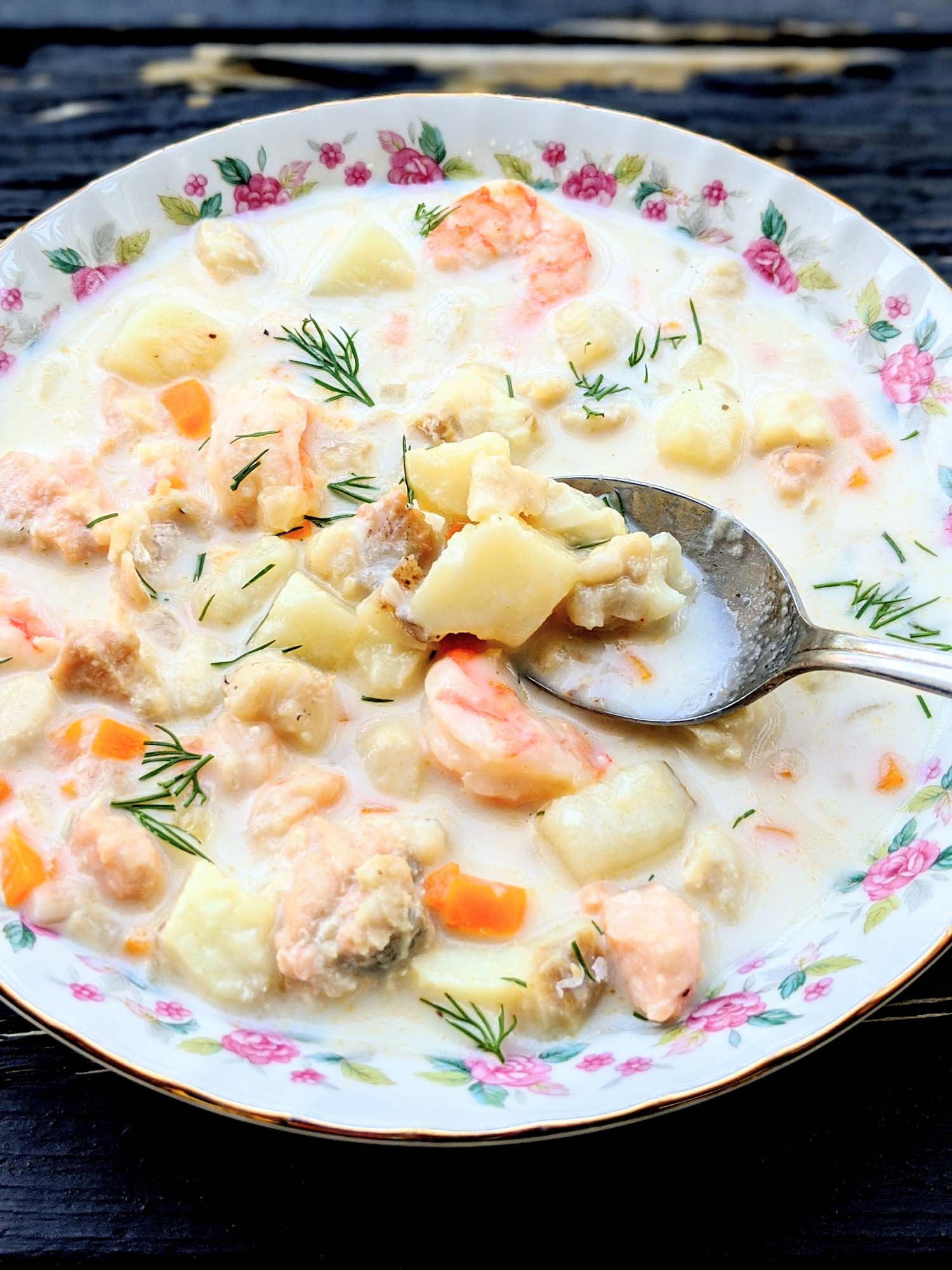 Nova Scotia seafood chowder in a vintage bowl on a black wooden background.