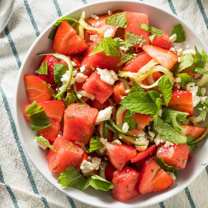 Watermelon feta mint salad in a bowl on a tea towel.