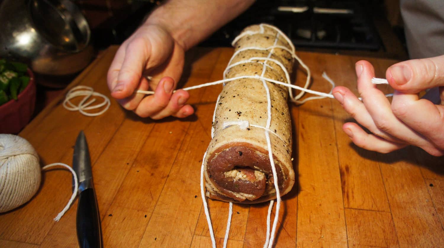 Tying a butcher knot on a roll of pancetta