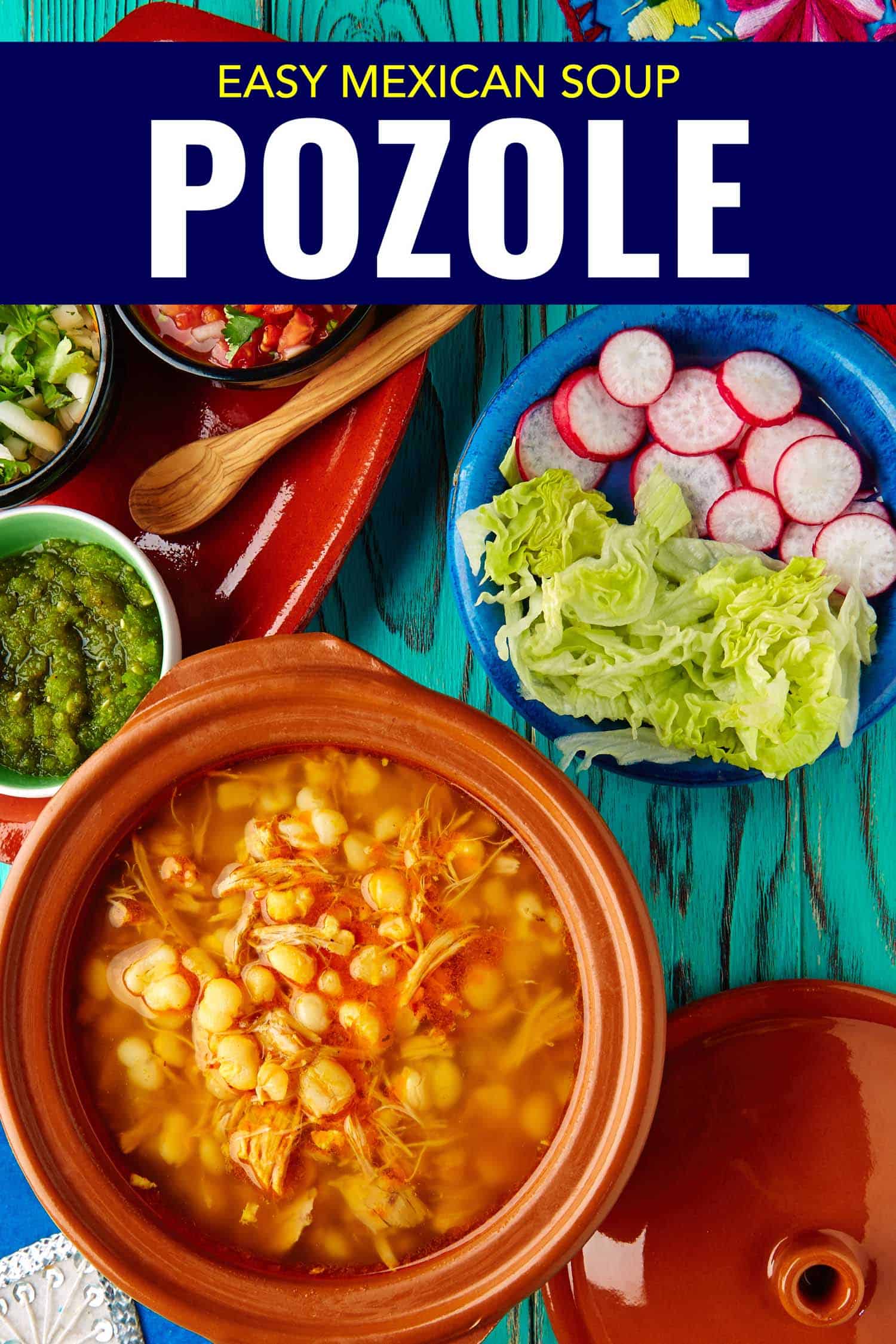 Mexican stew called pozole on a bright background with all of the garnishes like radish, lettuce and salsa