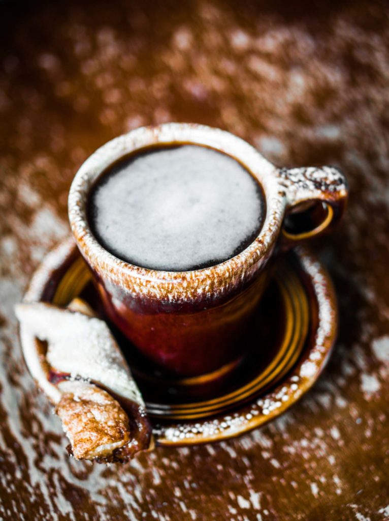 Rustic mug of coffee on wooden background