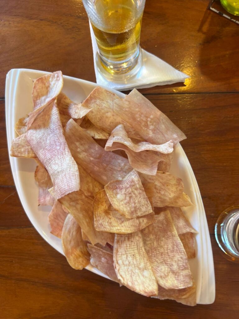 chicharritas de malanga on a white plate with a draft beer in the background at a restaurant in Vinales Cuba