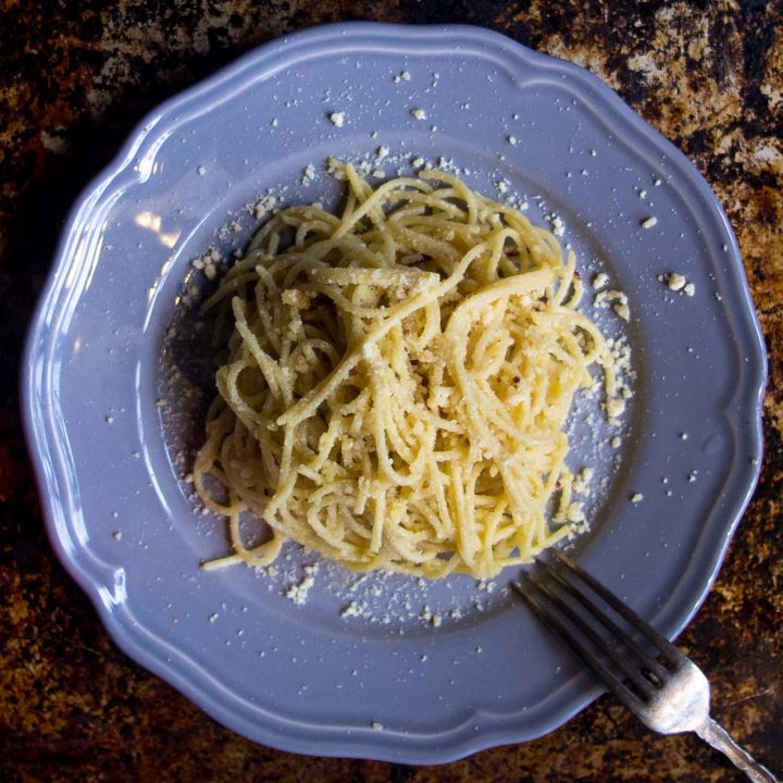 Spaghetti aglio olio on a blue plate and rustic background