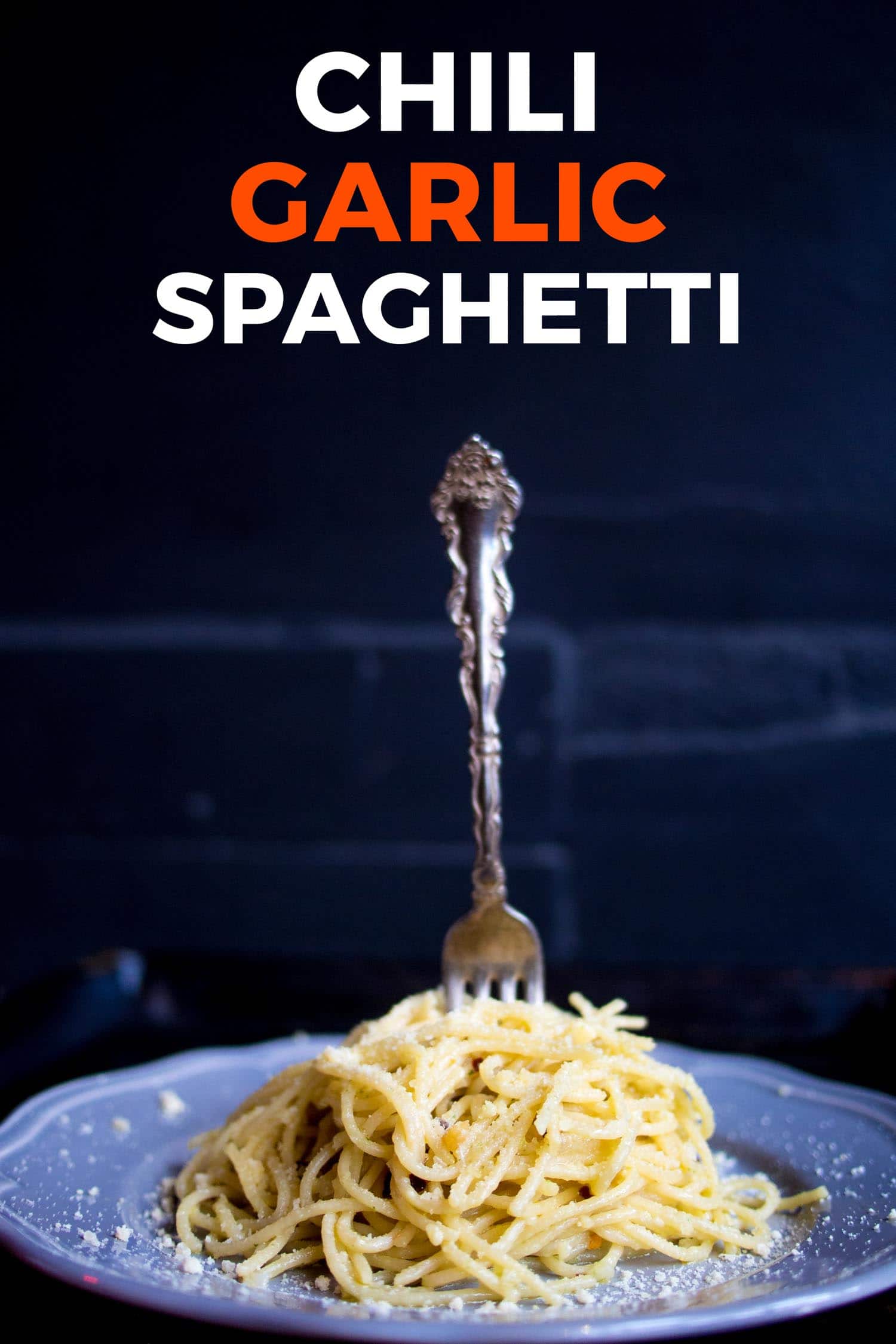 Chili garlic parmesan spaghetti on a blue plate on a rustic background.