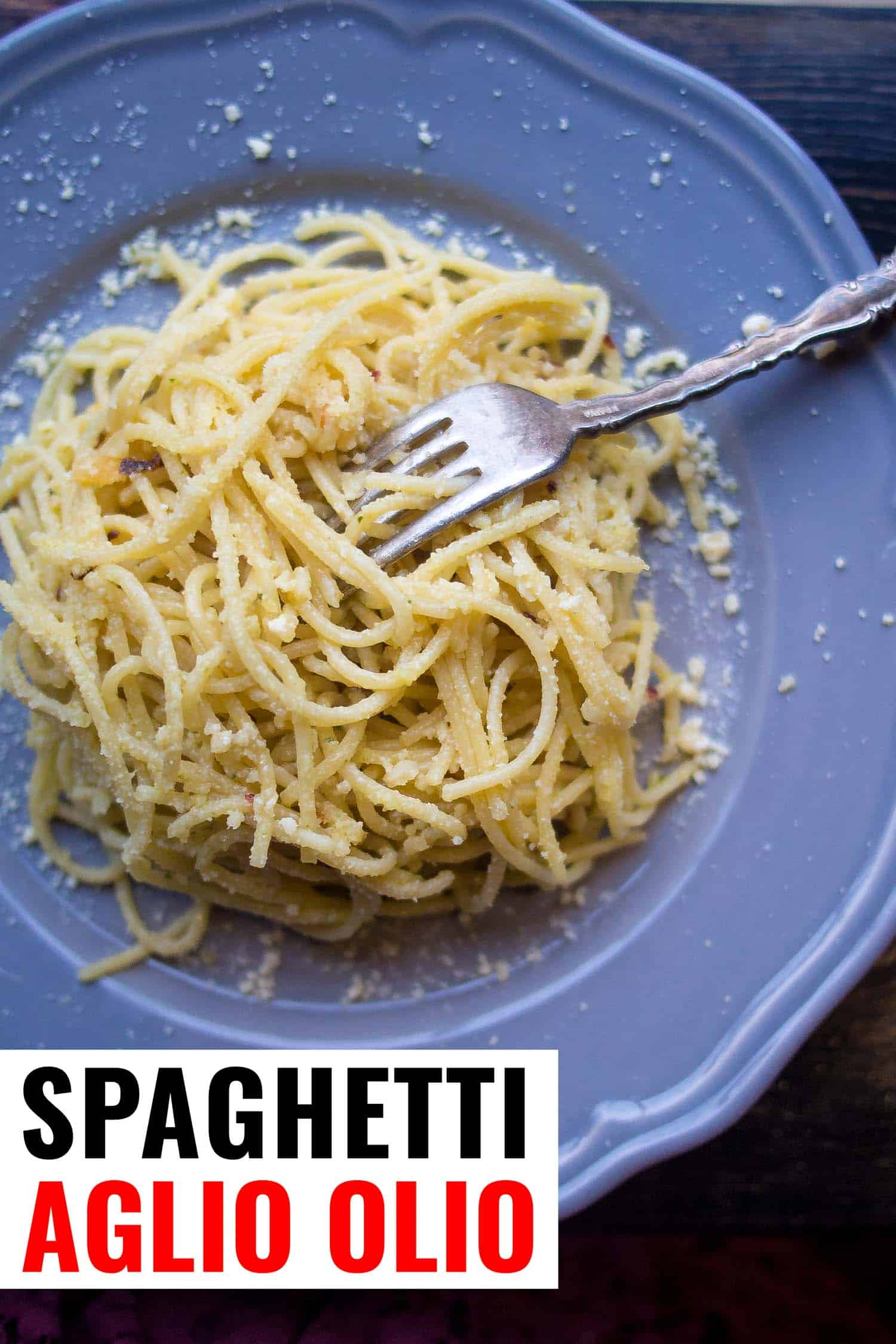 Spaghetti with garlic, chili flakes and parmesan on a blue plate.