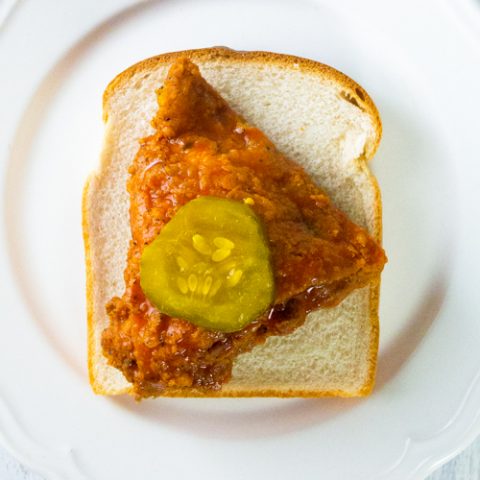 Spicy fried chicken on a piece of white bread