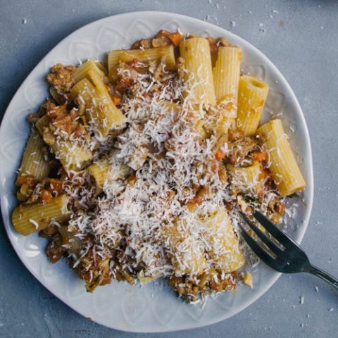 Pasta Bolognese on a white plate and pale blue background