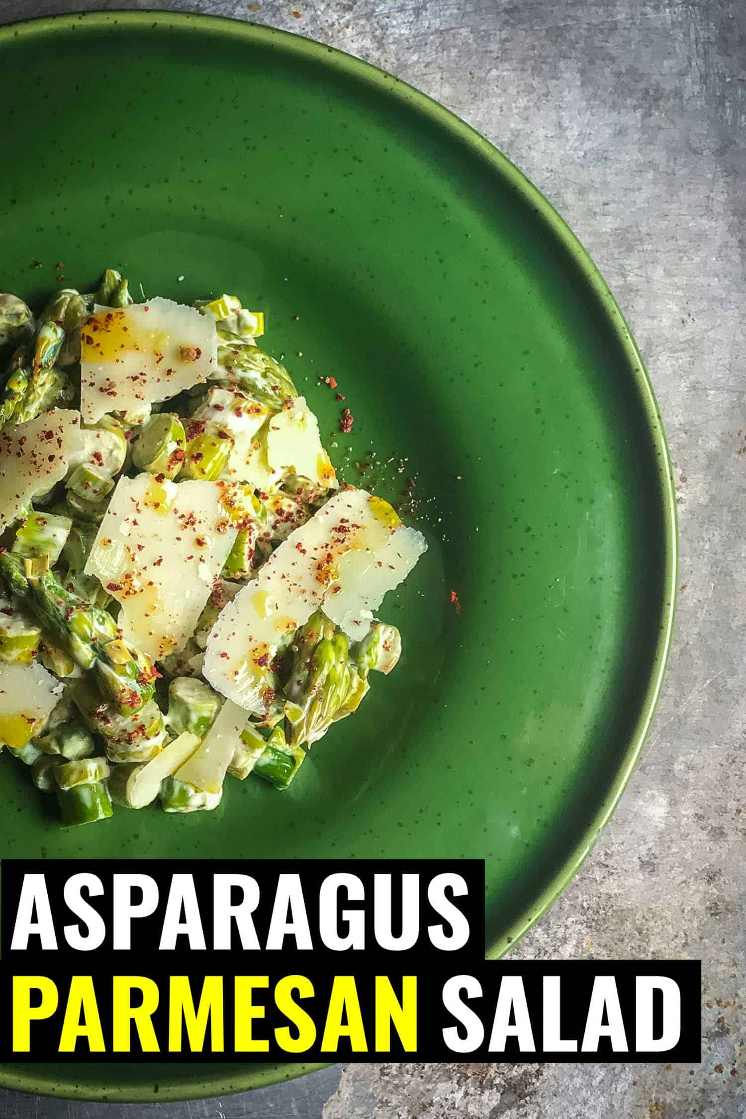 asparagus parmesan salad on a green plate and silver background