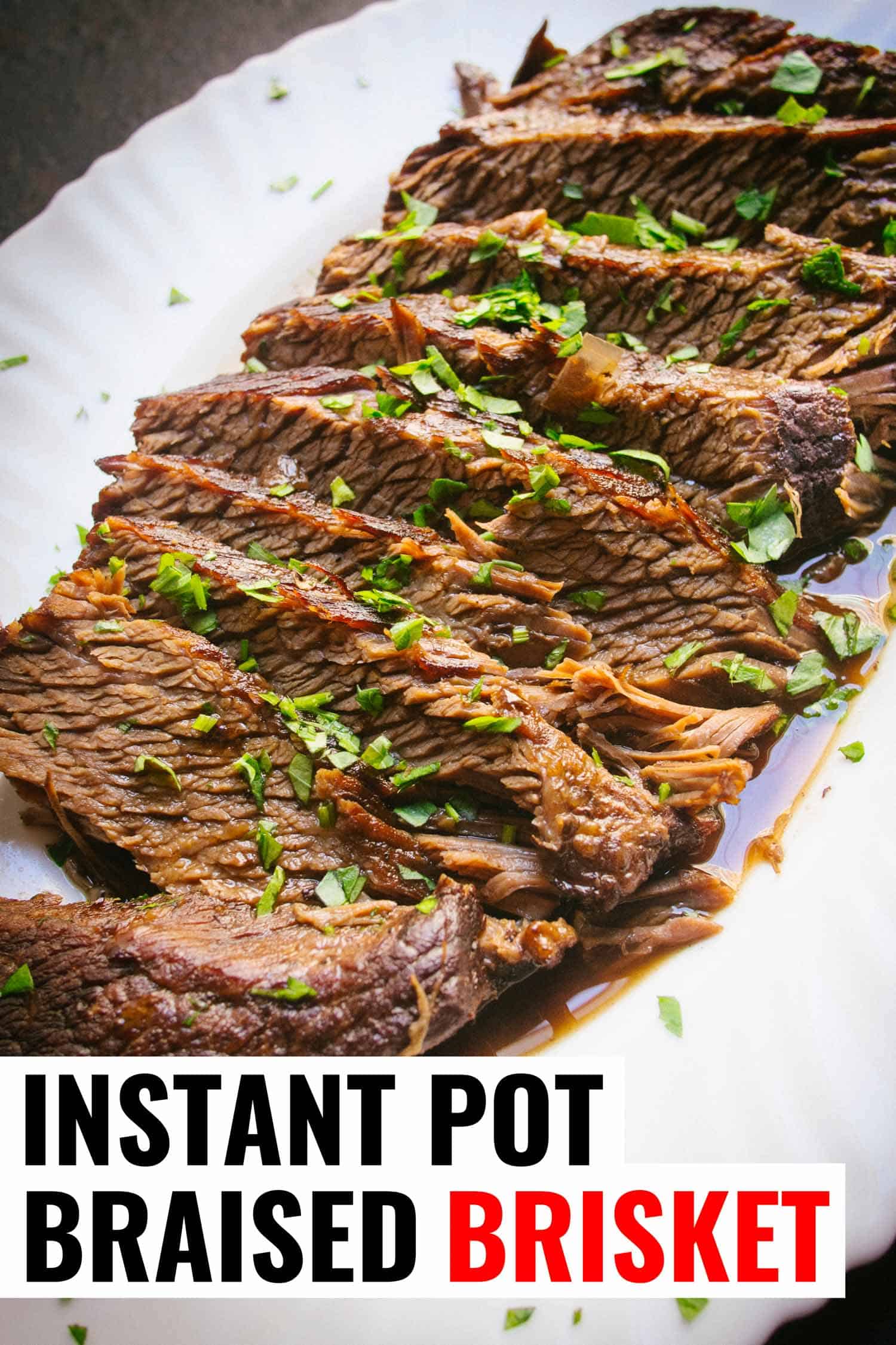 Sliced Instant Pot brisket on a white plate garnished with parsley