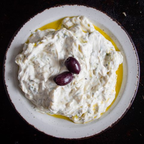 turkish cacik on a white plate and dark background.