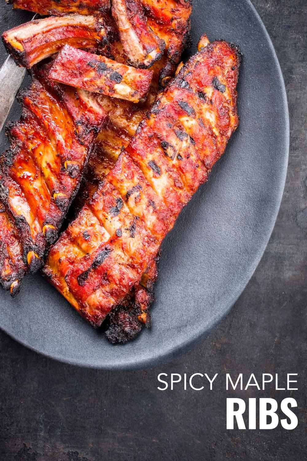 Spicy maple ribs uncut on a grey plate on a grey background.