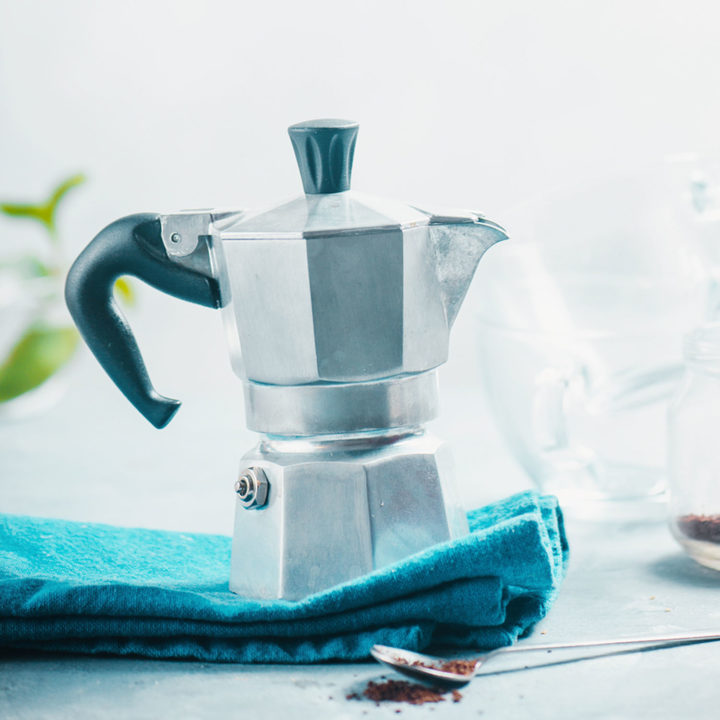 Brewing coffee in Moka pot for Cuban coffee on white