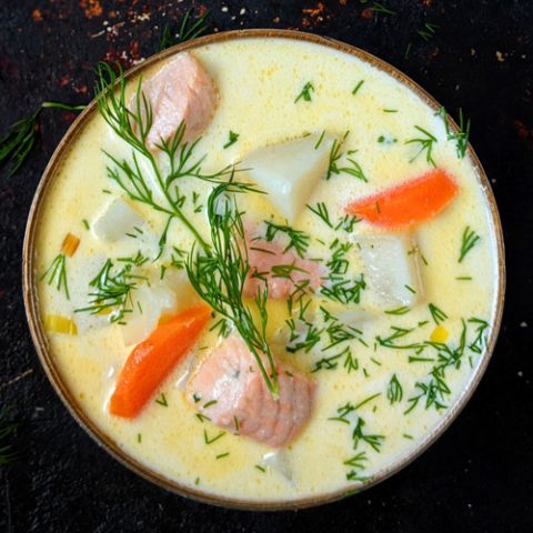 Lohikeitto Finnish salmon soup in a bowl on a dark background