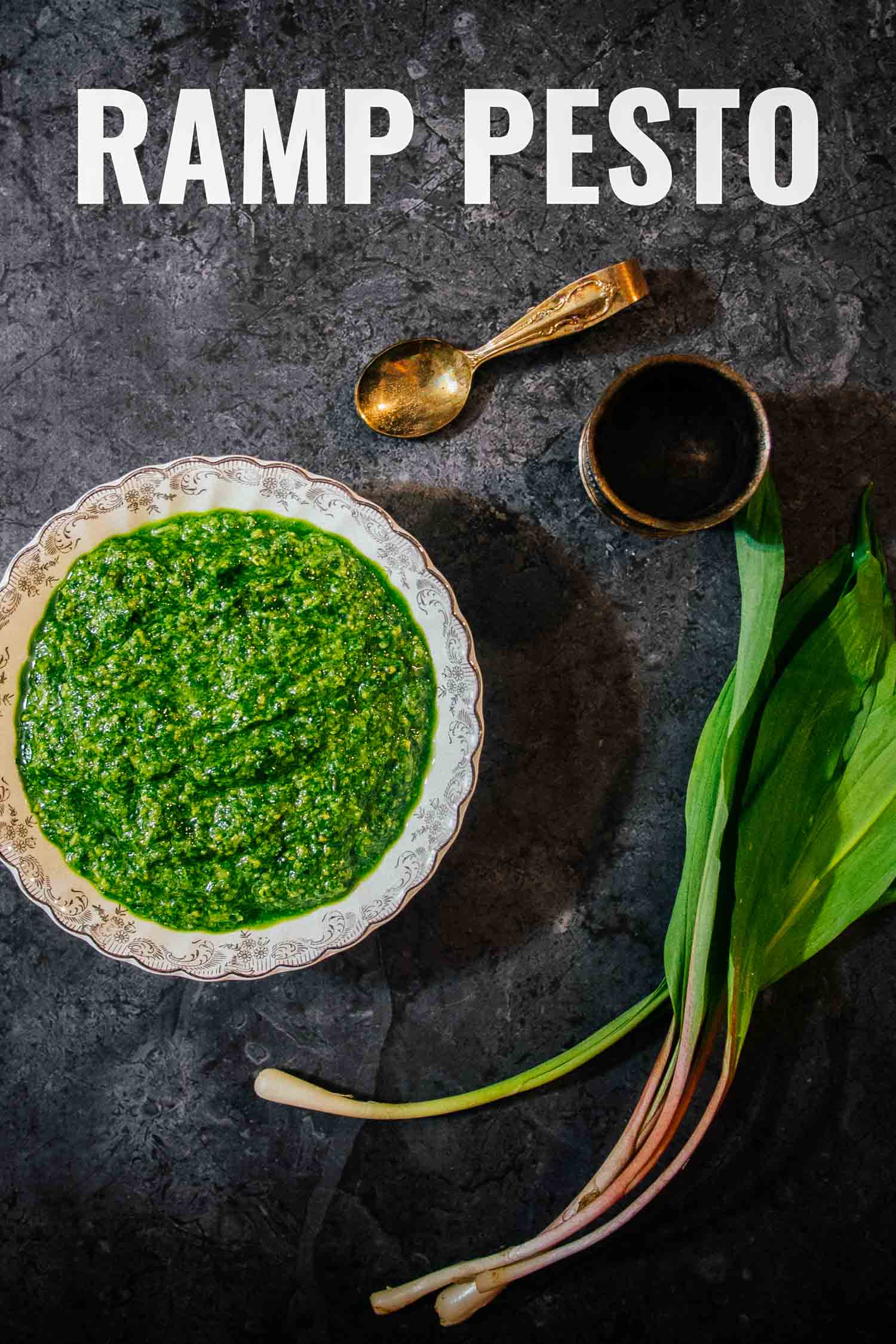 Ramps also known as wild leeks with ramp pesto and a spoon on a dark background.