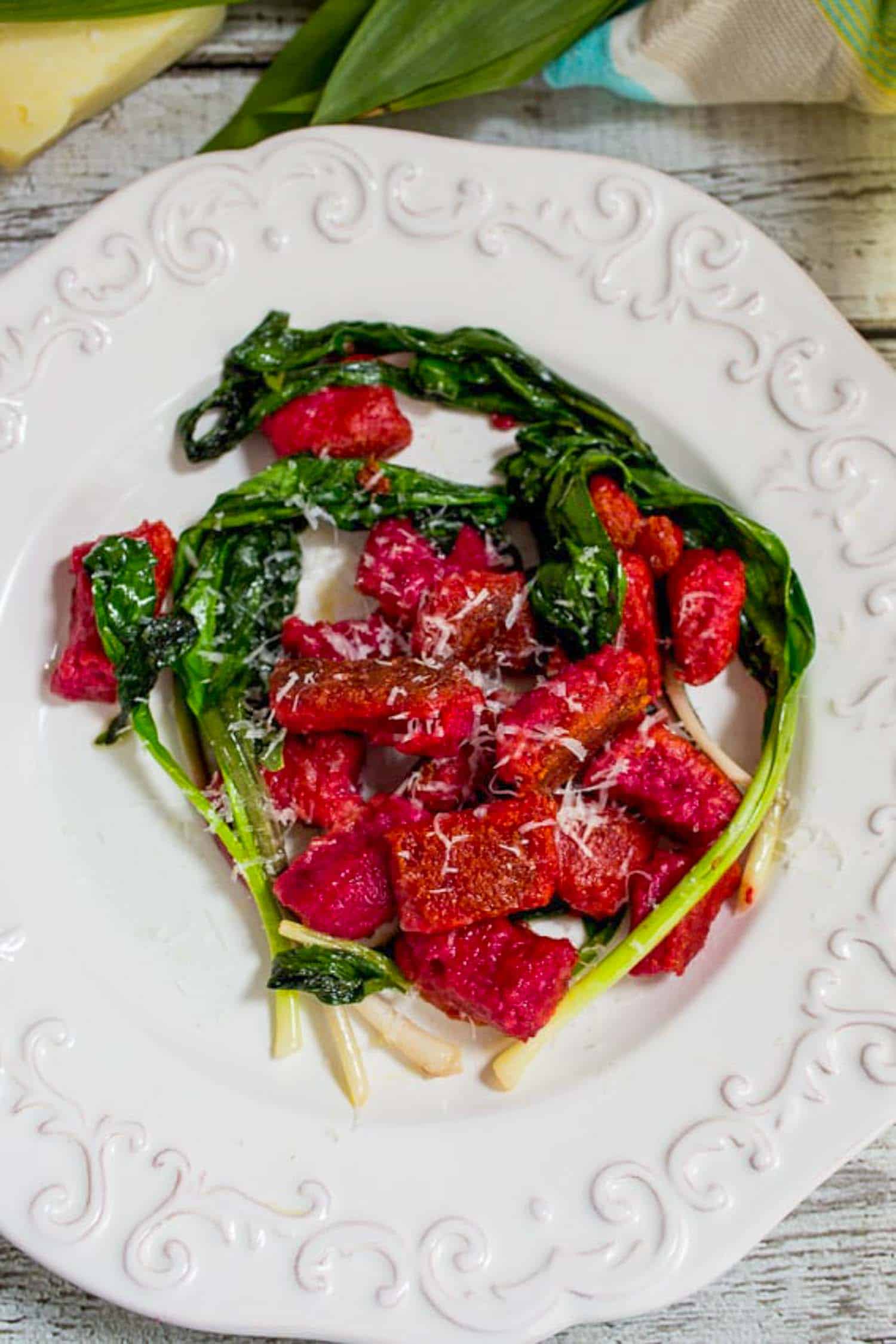Beet Ricotta Gnocchi with Ramps on white plate