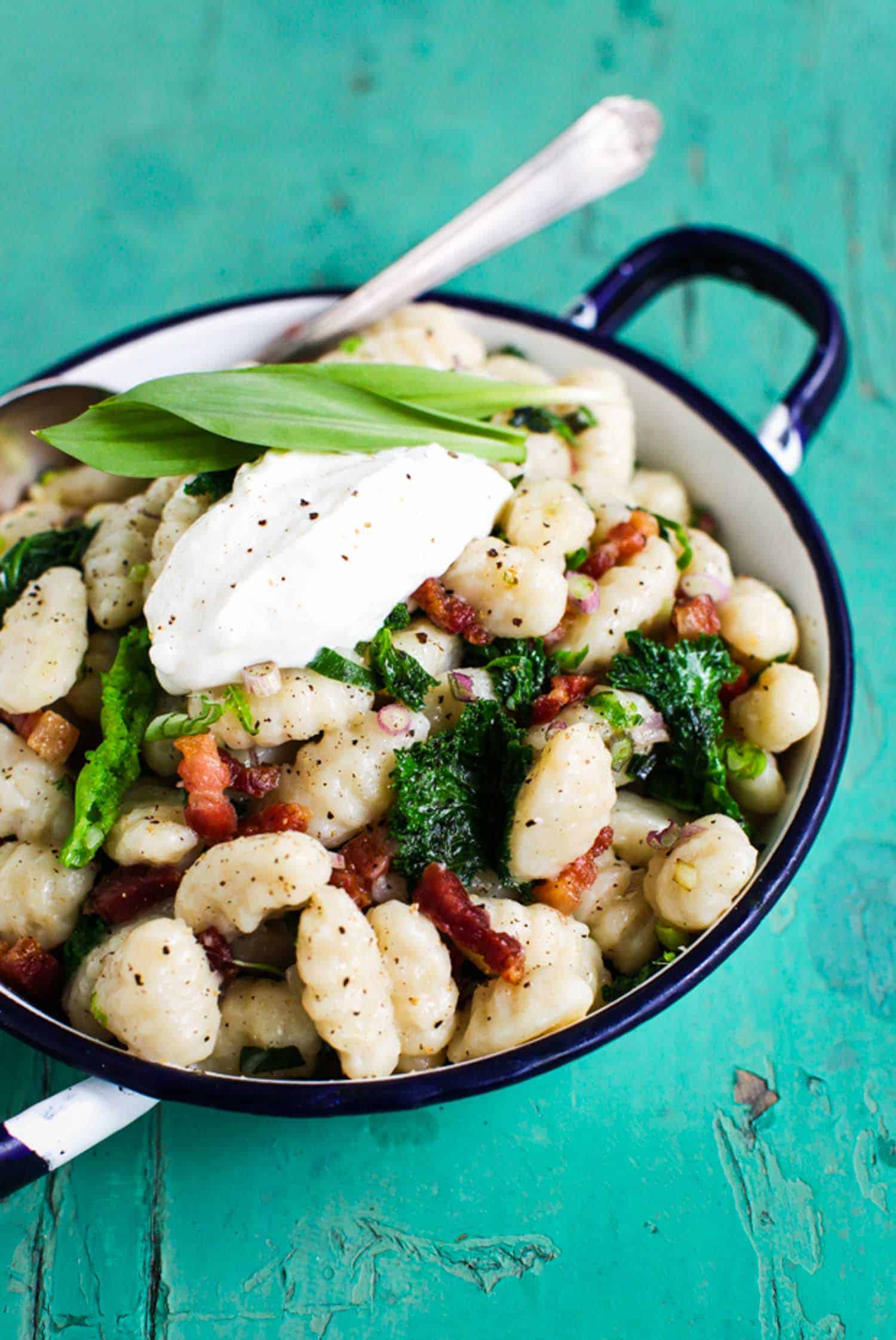 Ramp recipe gnocchi with kale in a white pot on a green background
