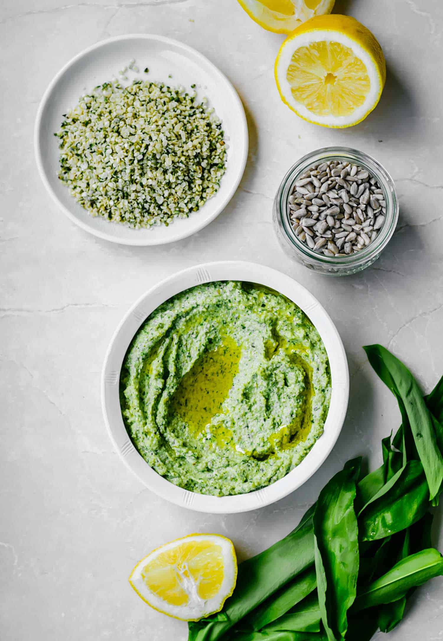 Wild Garlic Hemp and Sunflower Seed Pesto, also known as ramps, in a white bowl on white background