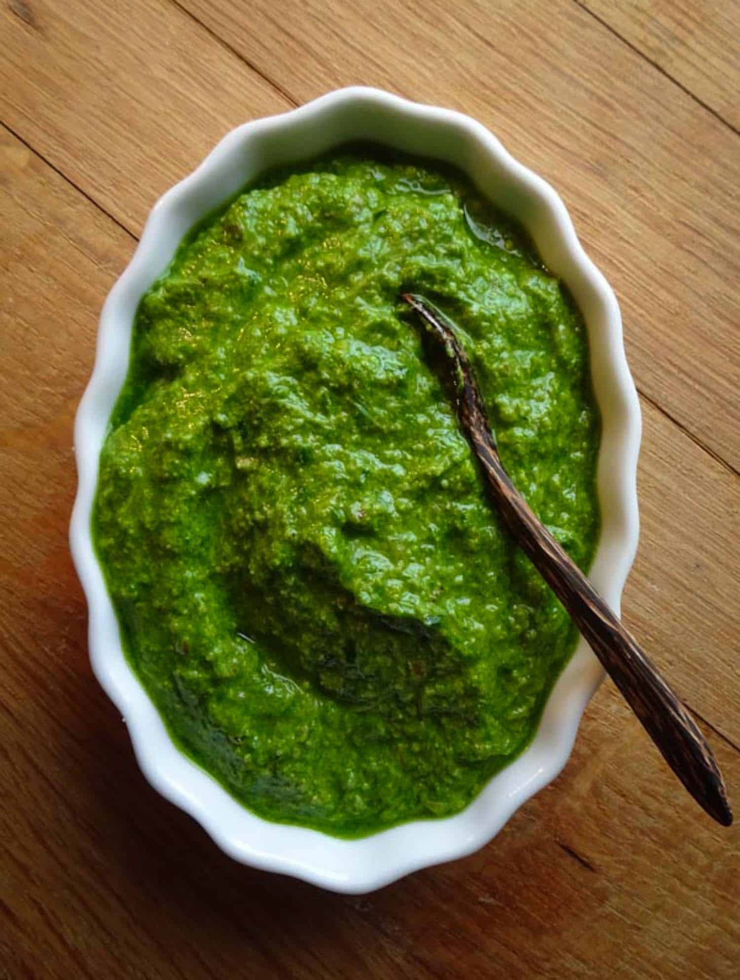 Ramps recipe of pesto in white bowl on wooden background.