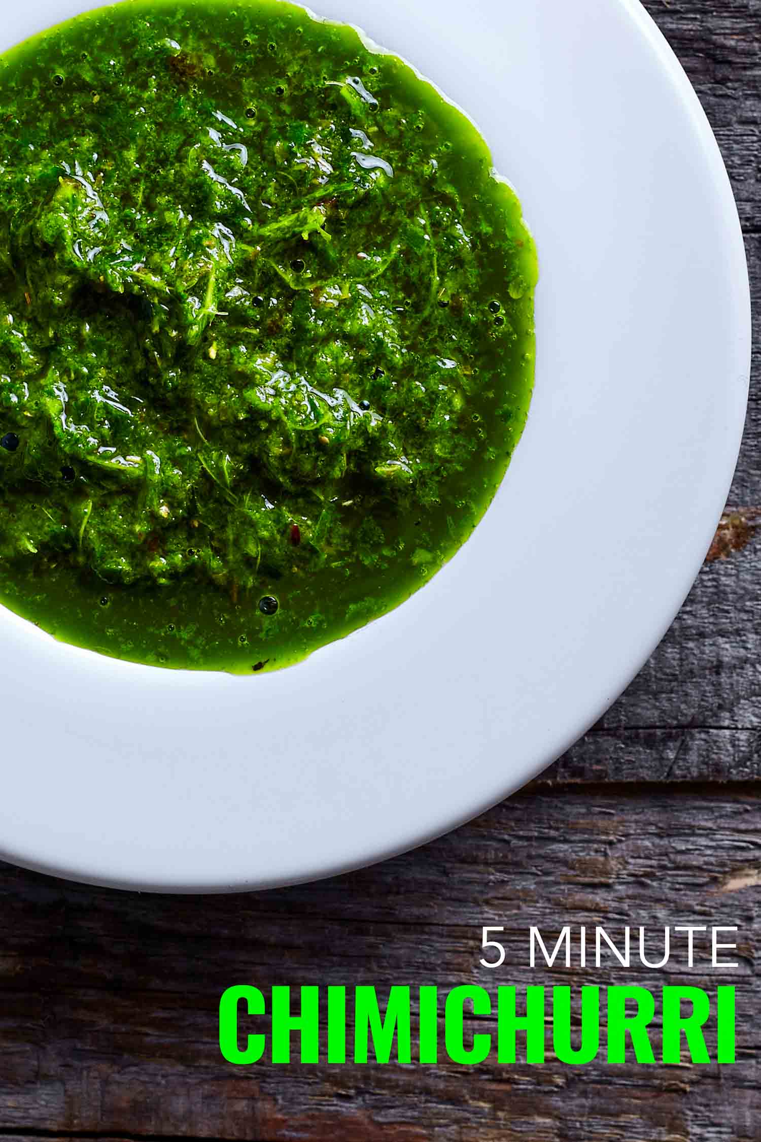 Chimichurri in a white bowl on a wooden background.