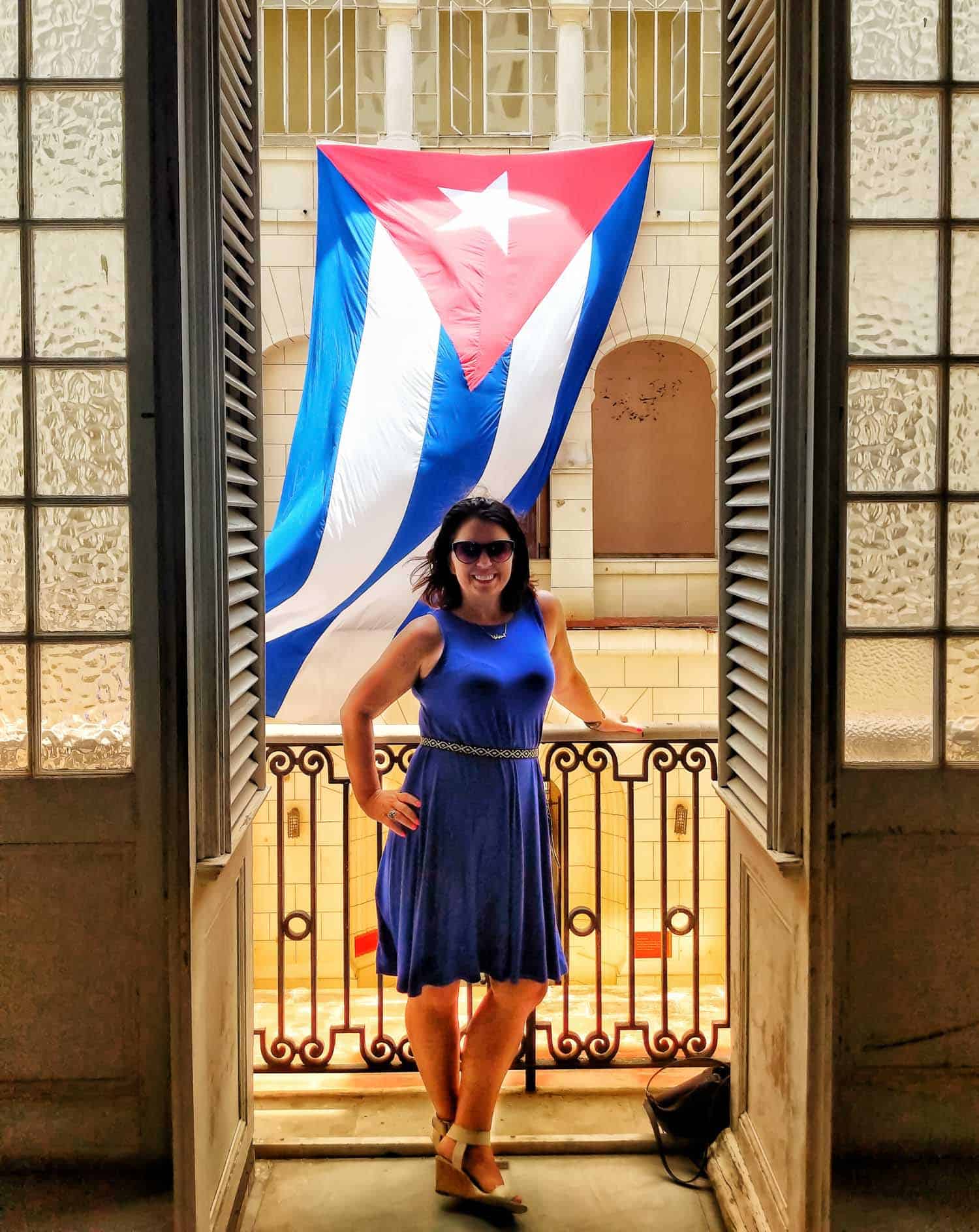 Ayngelina Brogan standing in front of Cuban flag at the museum of revolution in Havana Cuba