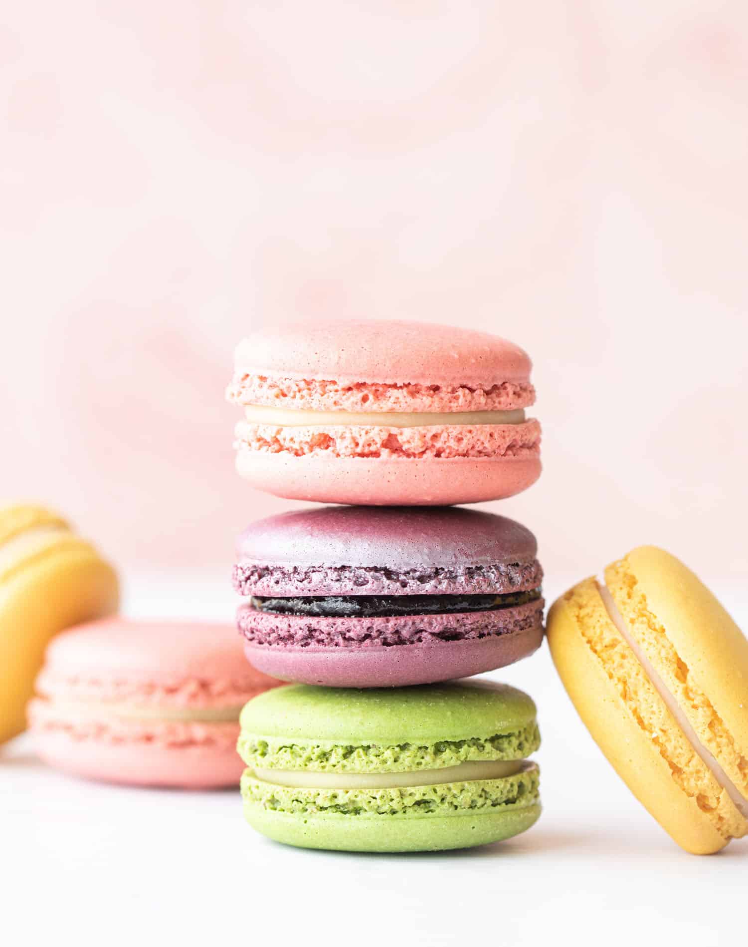 stack of French macarons on pink background