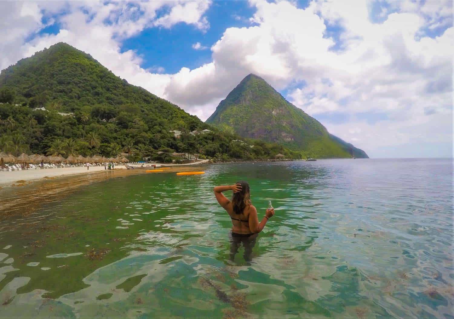 Woman in water at Jalousie beach in St.Lucia with mountains in background.