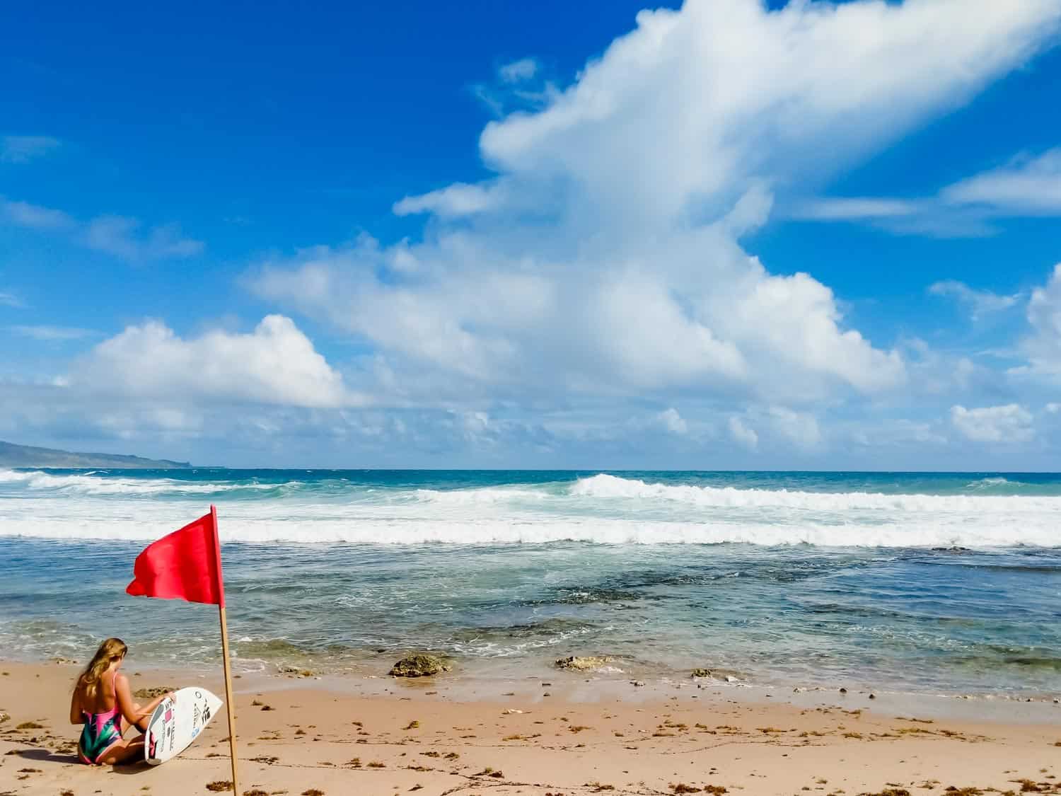 Bathsheba beach in Barbados with female surfer on beach