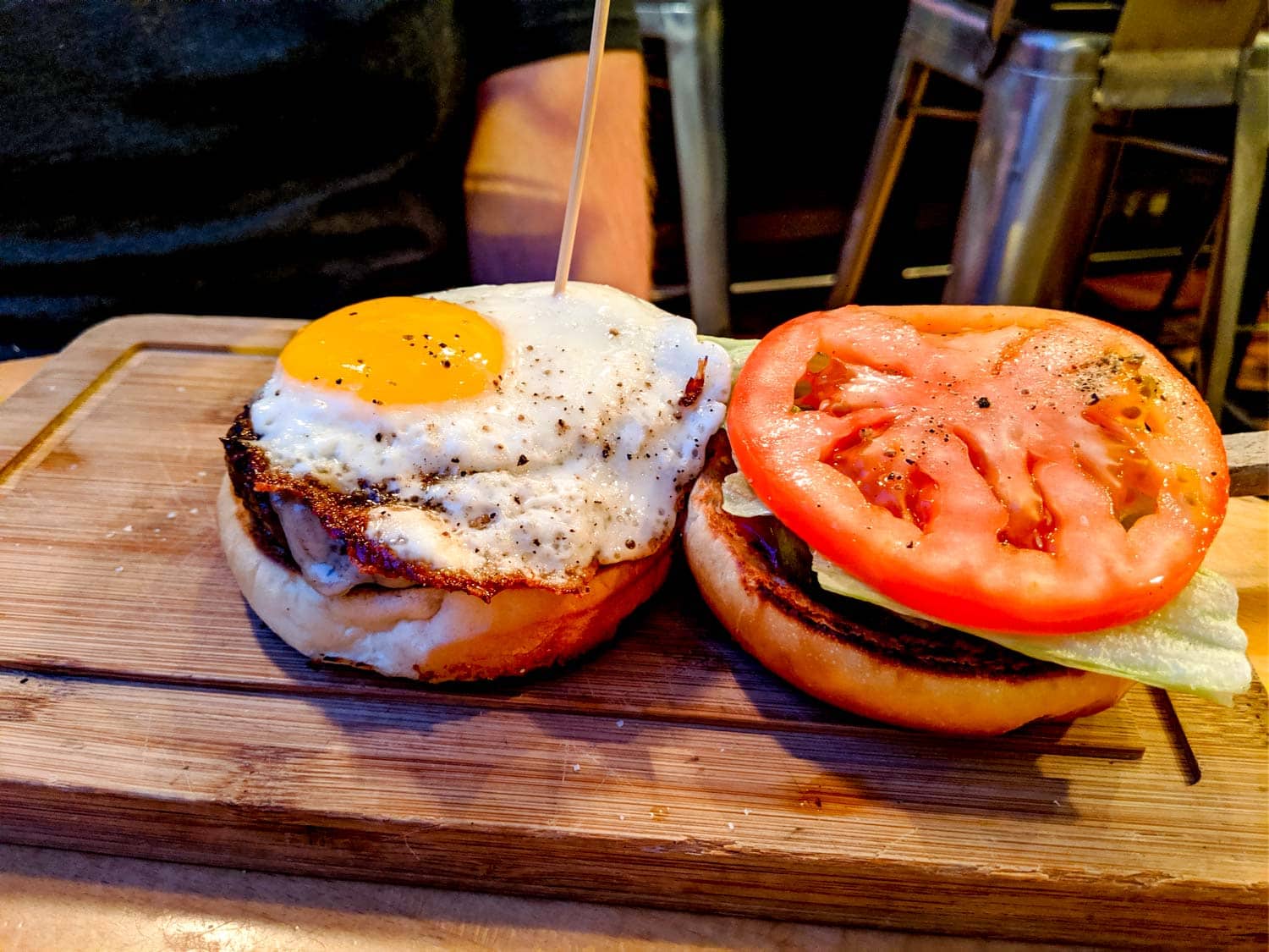 The butcher and burger with an egg, lettuce, tomato on a beef patty.