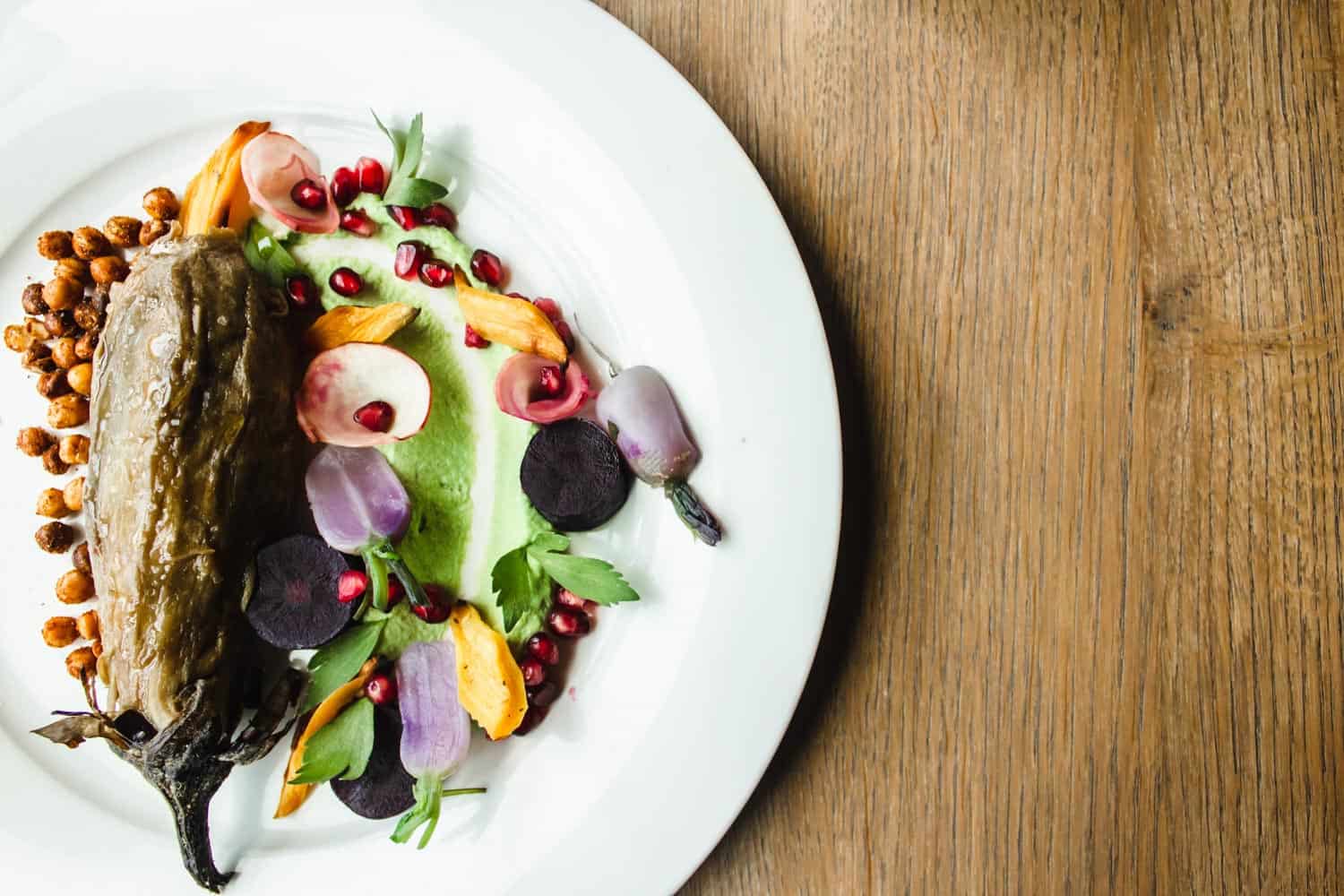 roasted pepper with chickpeas and vegetables on a white plate.