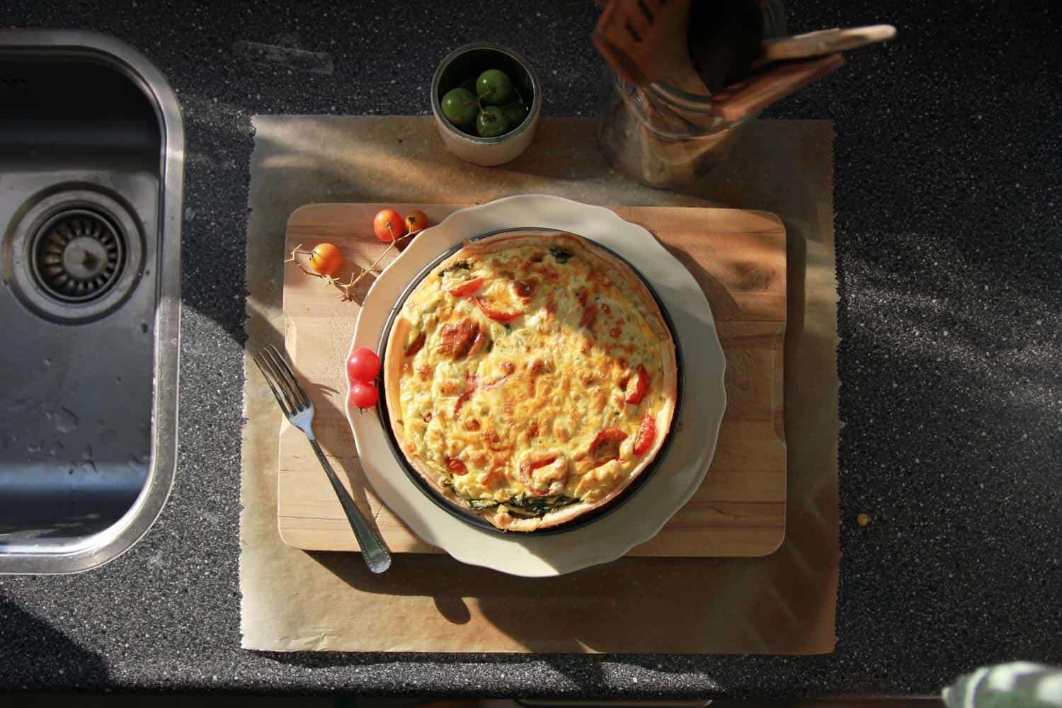 Traditional French cuisine, Quiche Lorraine on a cutting board in the sunshine.