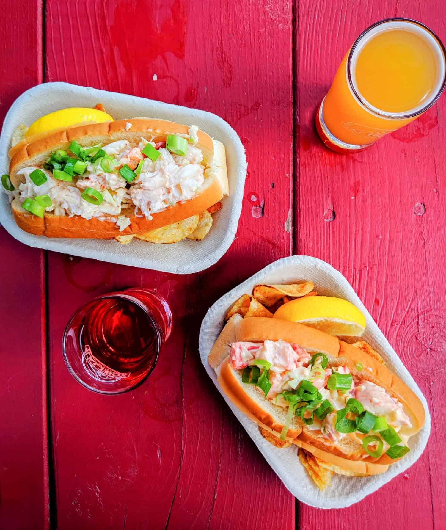 Typical Nova Scotia food, lobster roll on red picnic table with craft beer