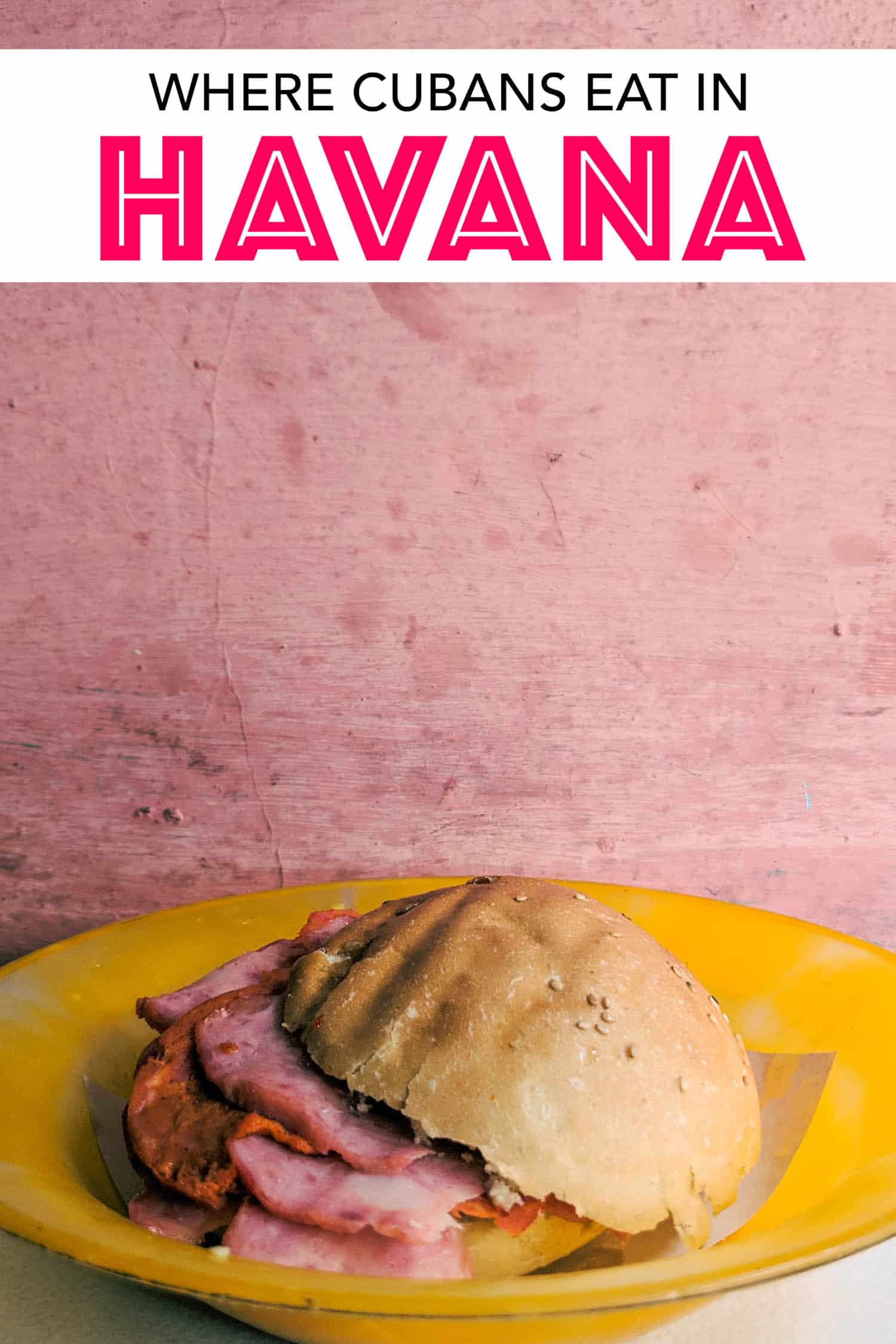 Typical Cuban sandwich with ham and cheese on pink wall