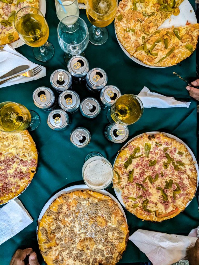 El Bosque pizza restaurant in Havana between Vedado and Miramar neighbourhoods. Flatlay of pizza and cans of beer