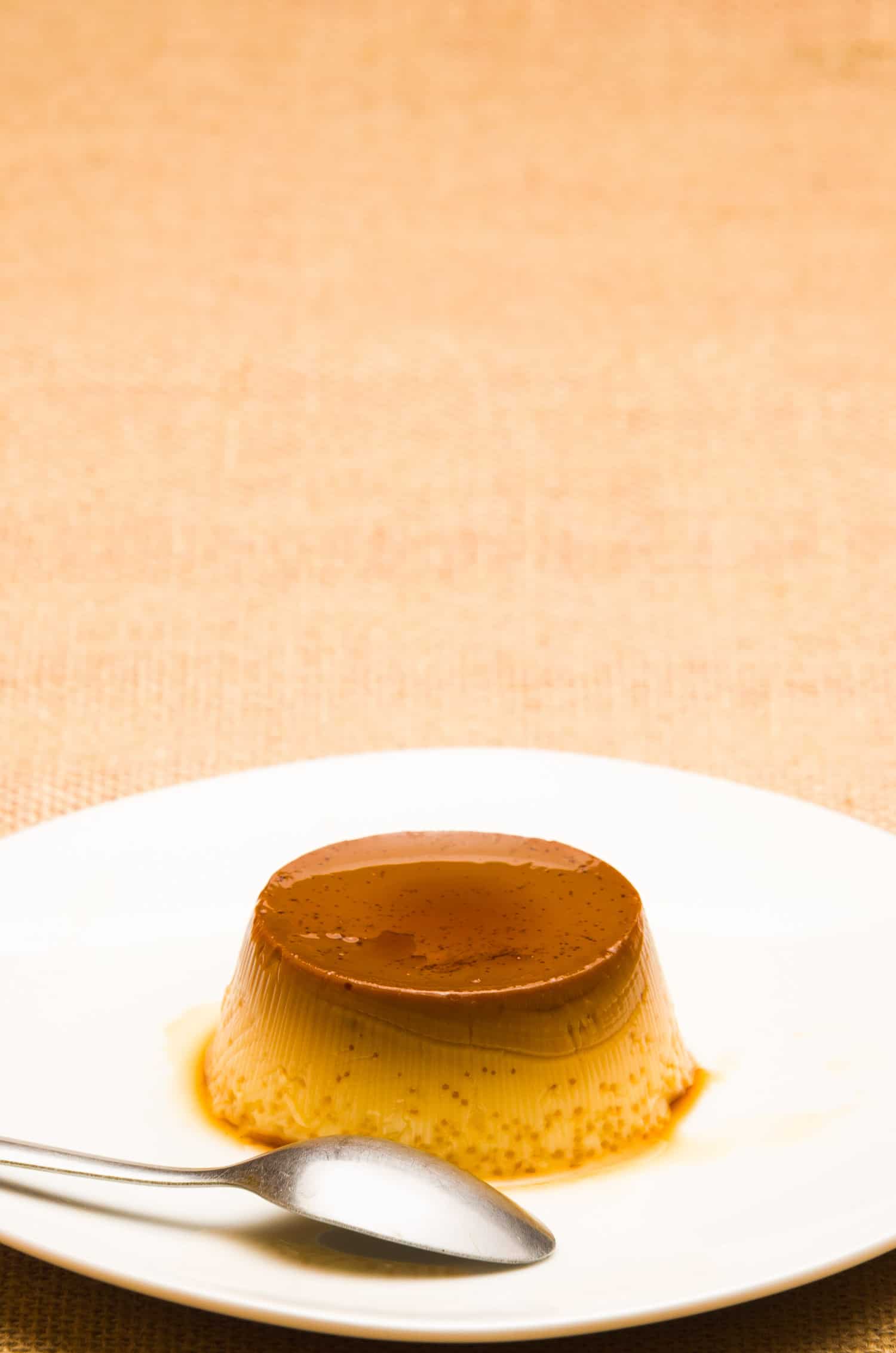 Caramel flan on a white plate.