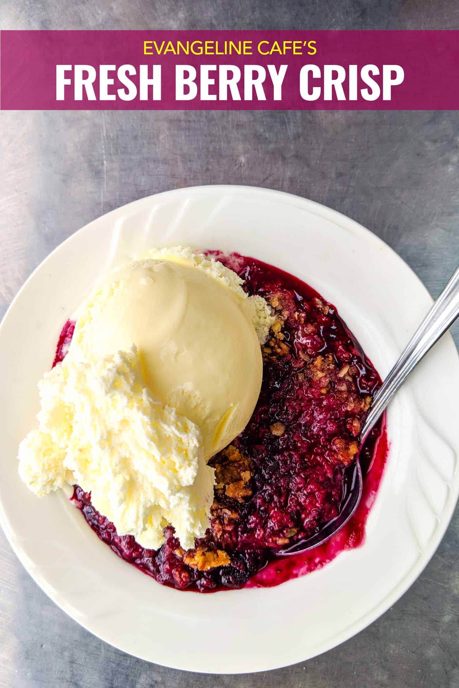 Mixed berry crisp recipe in white bowl on silver background, a classic Nova Scotian dessert.