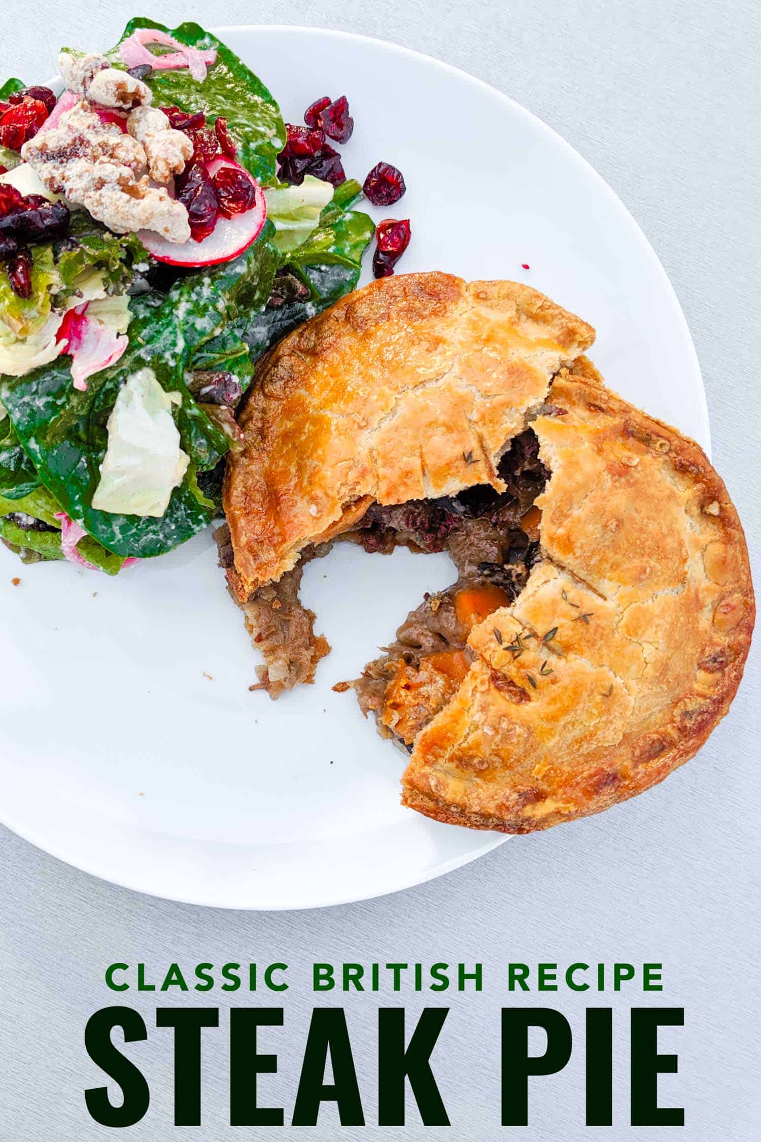 Steak and mushroom pie recipe on a plate with a green salad.