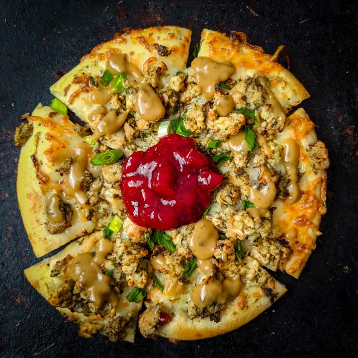 Christmas pizza or thanksgiving pizza using turkey dinner leftovers on black.