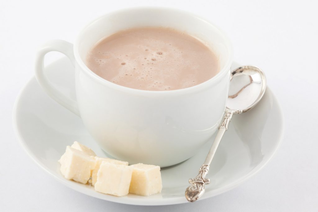 Cup of hot chocolate with cheese served in white dishware