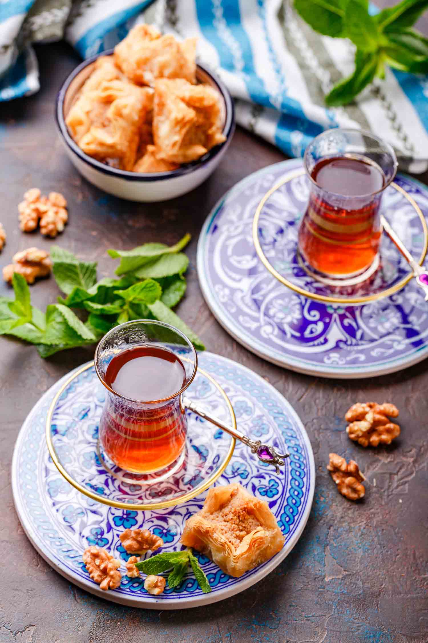 Middle Eastern or Arabic tea with mint in a traditional glass cup and Turkish sweetness Baklava. Ramadan kareem. Eid mubarak. Islamic holidays decoration.