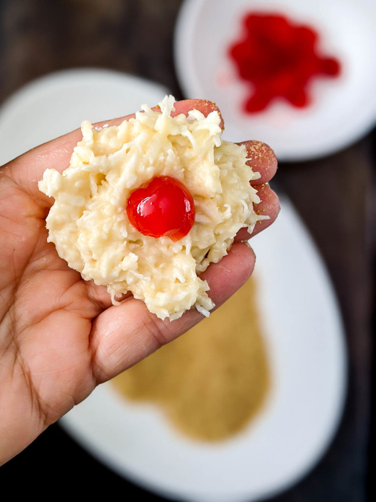 Coconut cherry balls in process shot, cherry in dough