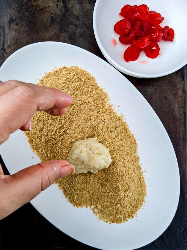 Coconut cherry balls in process shot dough placed on graham crackers