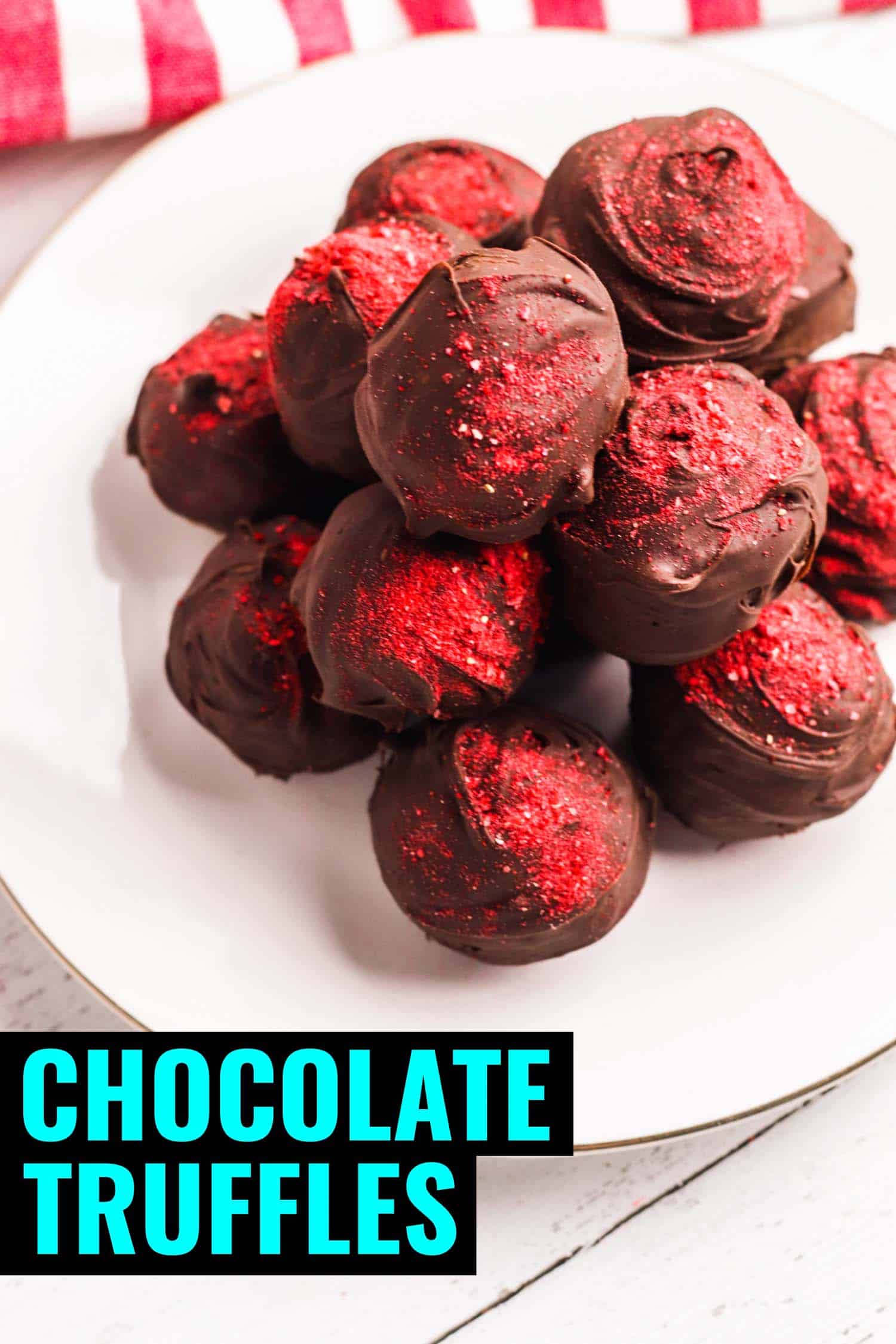 Chocolate strawberry truffles on a white plate with a red and white tea towel.