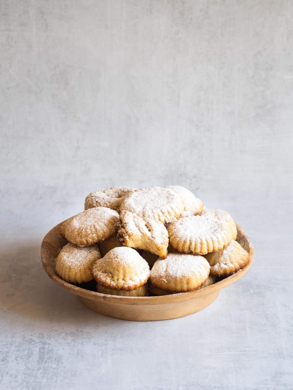 Khak Ramadan Holiday cookies sprinkled with powder in a wooden bowl. Egyptian cookies "Kahk El Eid". Cookies of El Fitr Islamic Feast.