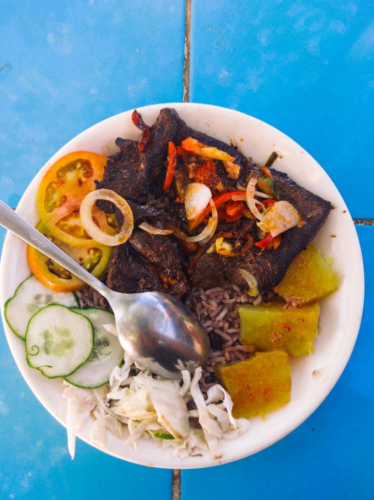 Cuban food, liver, malanga, tomatoes, cucumbers and cabbage on a plate