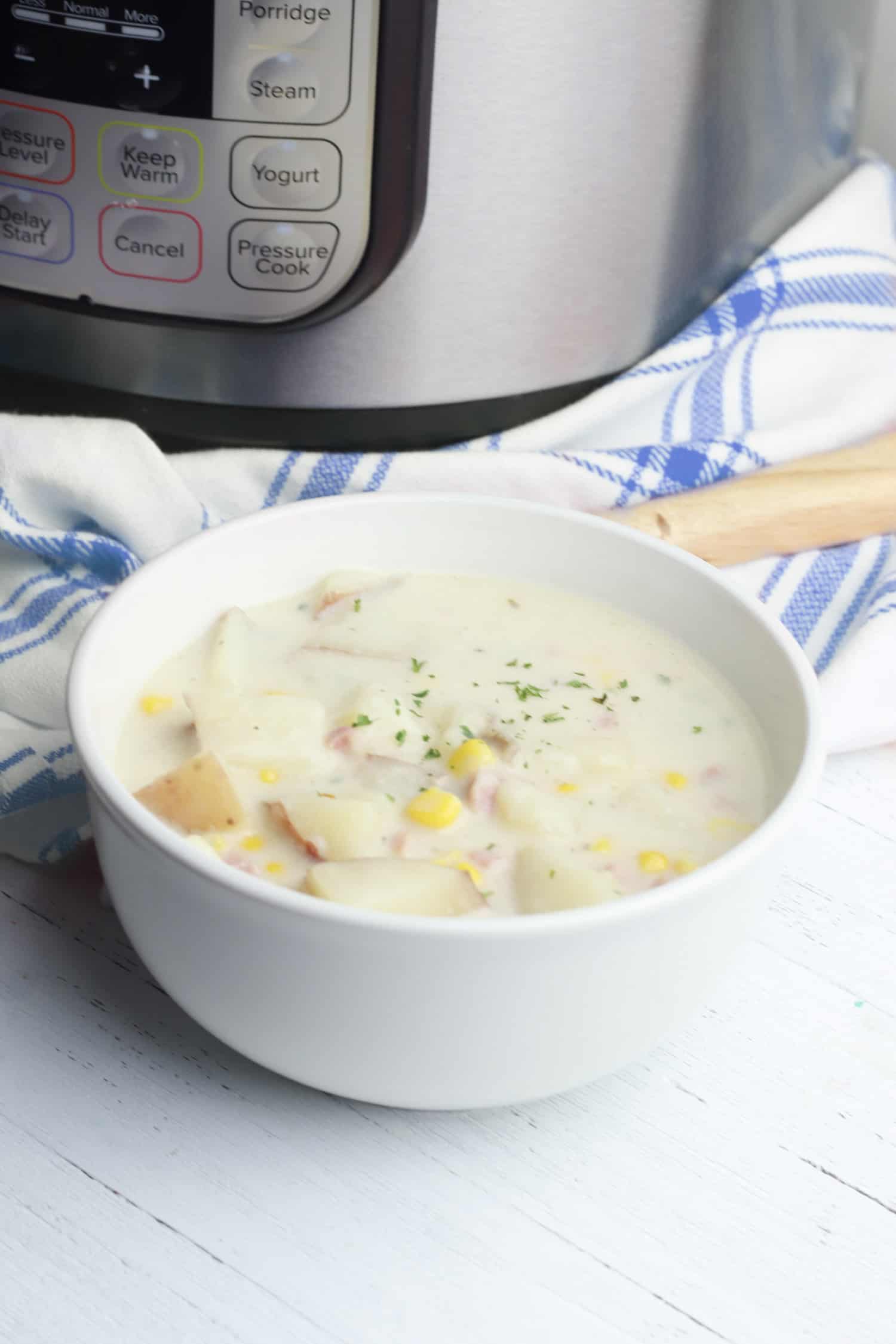 bowl of corn chowder next to an instant pot