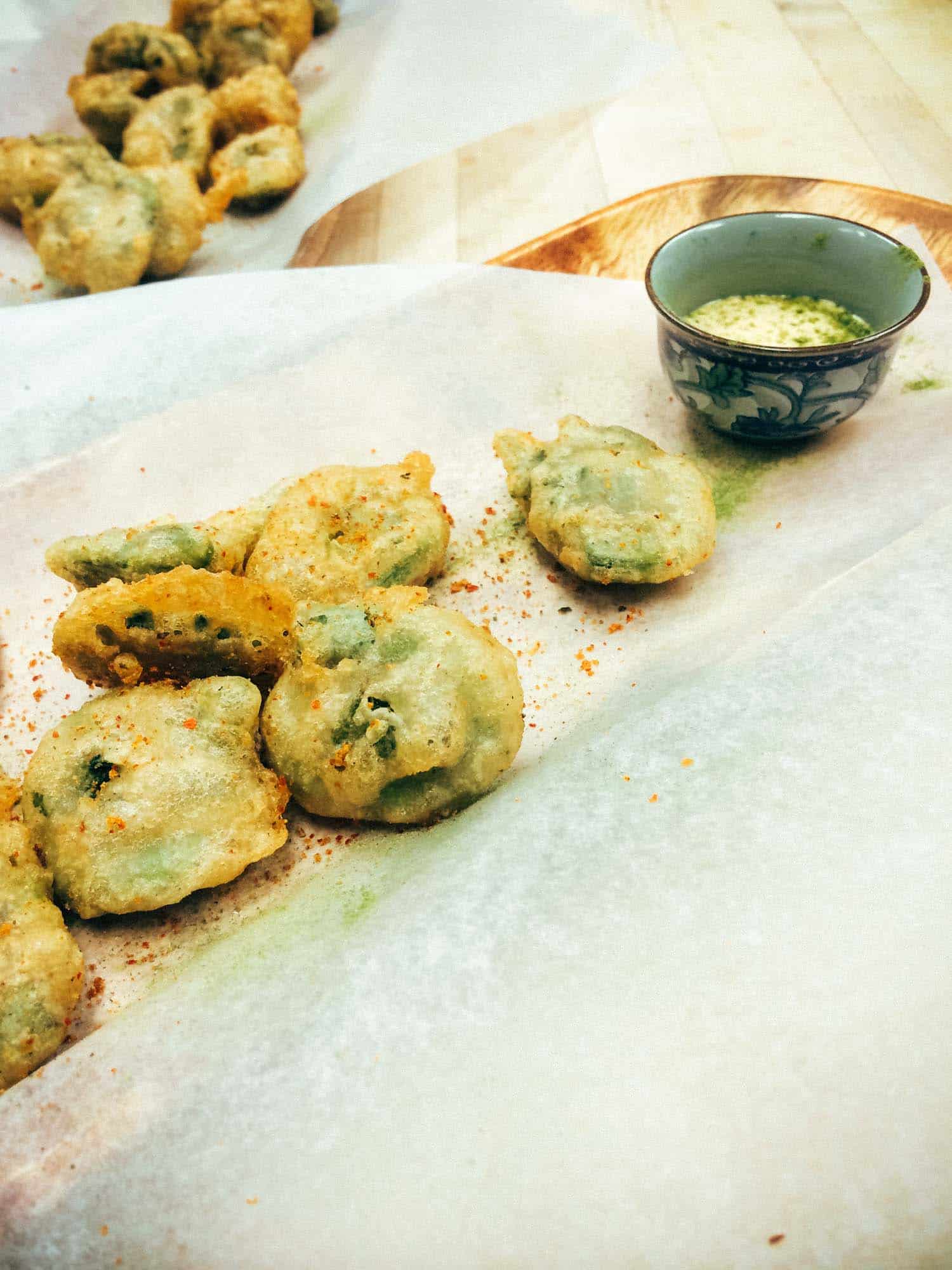 beer battered fiddleheads on white parchment paper